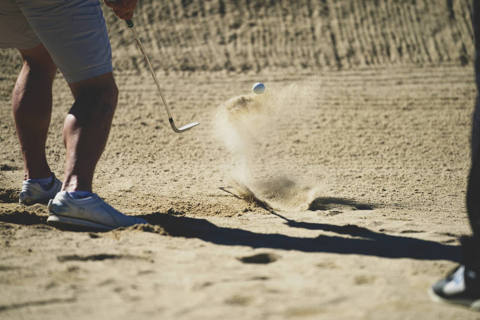 Golfeur sortant une balle d'un bunker